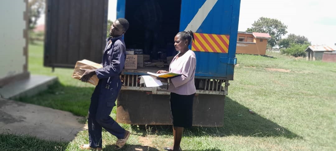 Edith Abeja, the District Health Educator receiving IEC materials at DHOs office
